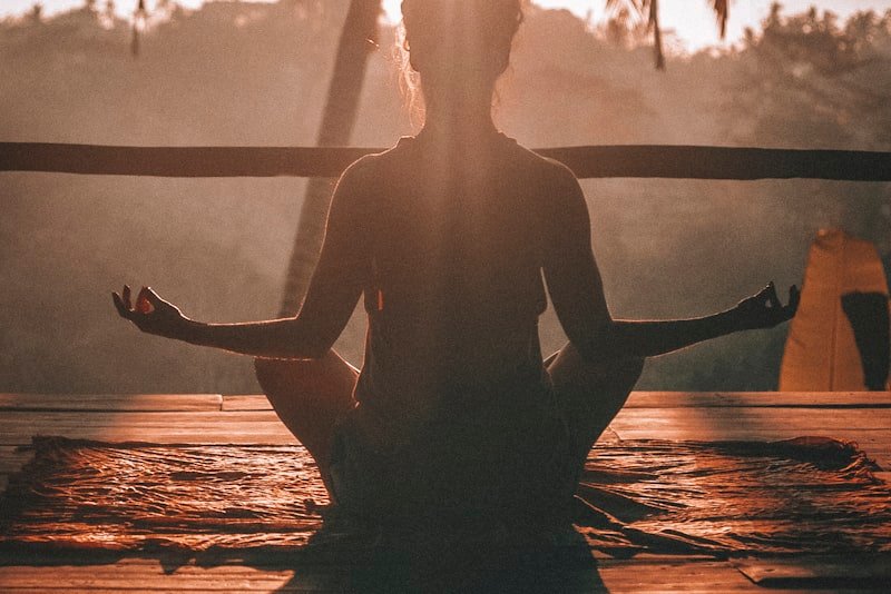 A woman seated quietly with eyes closed during a short breathing practice