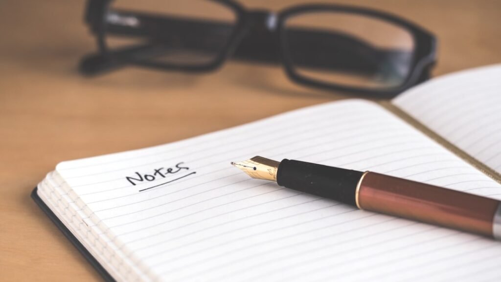 An open notebook and pen on a desk for tracking symptoms