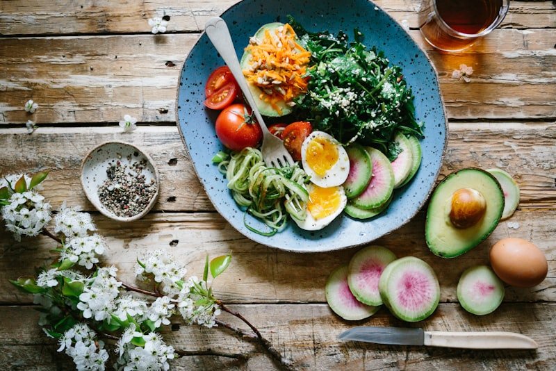 A balanced plate of salmon, leafy greens and whole grains photographed from above