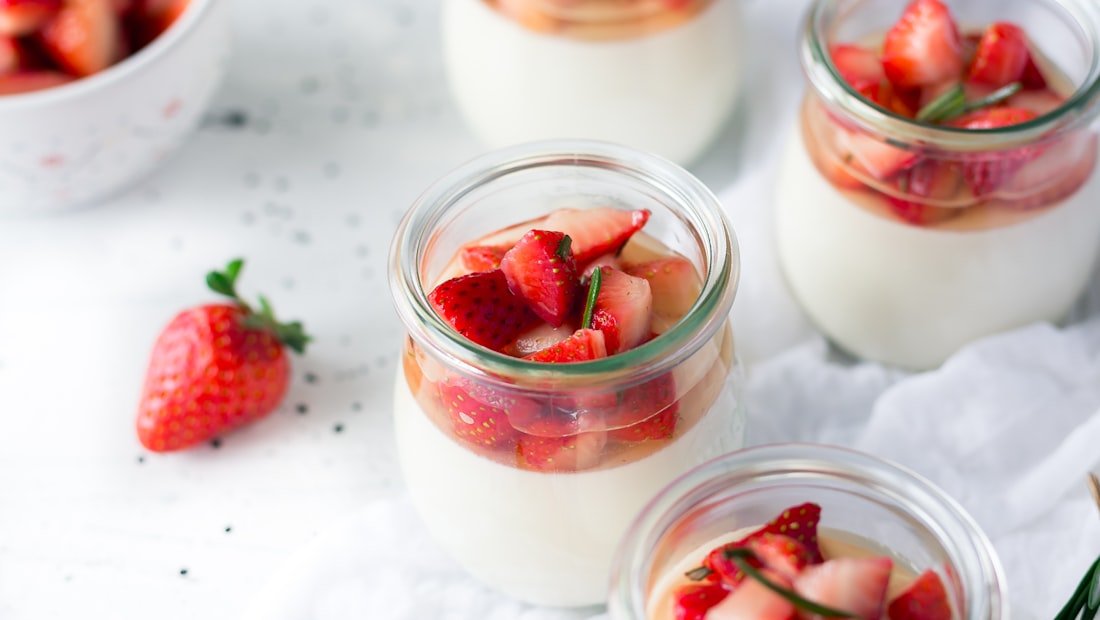 A bowl of yoghurt topped with seeds and berries